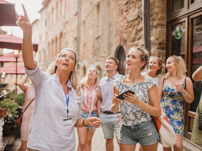 Fremdenführerin führt Gruppe durch eine unbekannte Altstadt